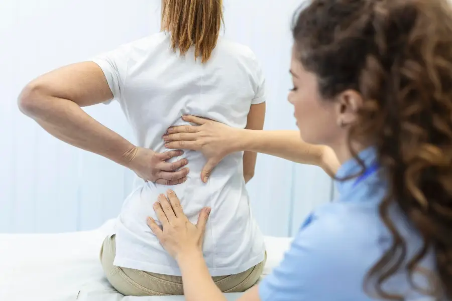 Physiotherapist doing healing treatment on womans back Back pain patient treatment medical doctor massage therapistoffice syndrome